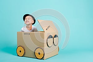 Baby children boy smile in driving play car creative by a cardboard box