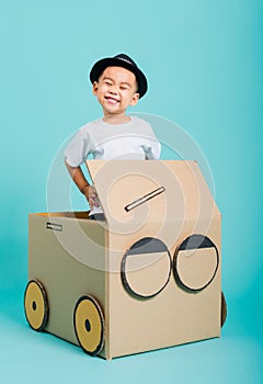 Baby children boy smile in driving play car creative by a cardboard box