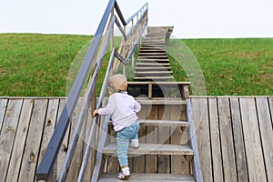 The baby climbs up a ladder into sky.