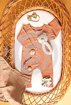 Baby clothes and accessories in basket bassinet.