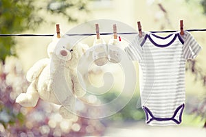Baby clothes, boots and teddy hanging on the clothesline
