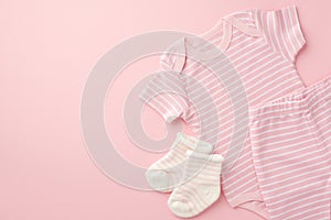 Baby clothes concept. Top view photo of pink shirt shorts and socks on  light pink background with copyspace