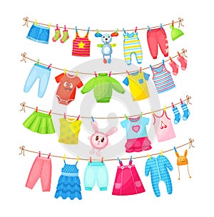 Baby clothes hanging on clothesline. Drying children`s clothes and accessories after washing on rope. Shorts, socks, romper, photo