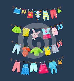 Baby clothes hanging on clothesline. Drying children`s clothes and accessories after washing on rope. Shorts, socks, romper,