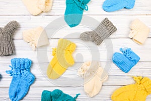 Baby clothes knitted booties on a white wooden background. View from above - Image