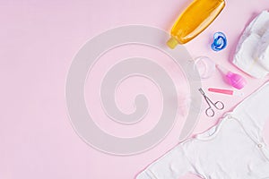 Baby clothes and other stuff for child on pink background. Newborn baby concept. Top view