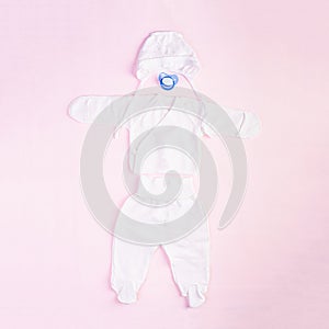 Baby clothes and other stuff for child on pink background. Newborn baby concept. Top view