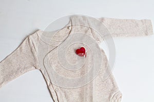 Baby clothes with test-tube and heart. Concept - IVF, in vitro fertilization. Waiting for baby, pregnant