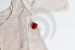 Baby clothes with test-tube and heart. Concept - IVF, in vitro fertilization. Waiting for baby, pregnant