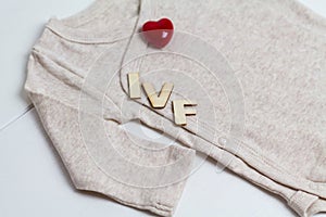 Baby clothes with wooden text IVF and heart. Concept - IVF, in vitro fertilization. Waiting for baby, pregnant photo