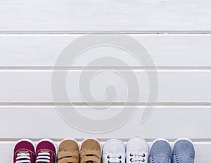 baby concept with four pairs shoes space wooden surface. High quality photo