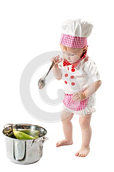 Baby cook girl wearing chef hat with fresh vegetables and fruits.