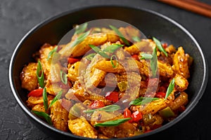 Baby Corn Manchurian dry looks like Schezwan Baby Corn in black bowl at dark slate background