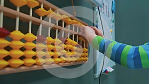 Baby counting on abacus playing in daycare with financial tools, elementary education Close up