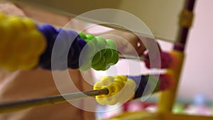 Baby counting on abacus playing game in daycare with financial tools, elementary education Close up