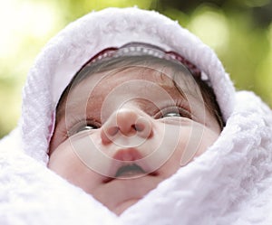 Baby in coverlet looking up