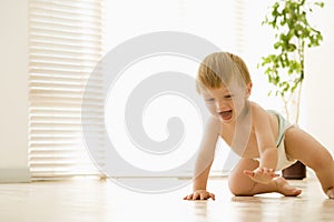 Baby crawling indoors smiling