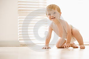 Baby crawling indoors smiling photo