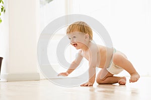 Baby crawling indoors smiling photo