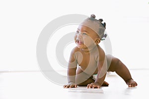 Baby crawling indoors smiling photo