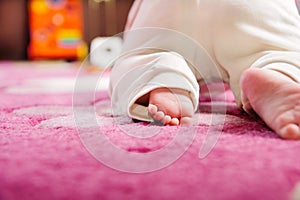 Baby crawling on pink carpet