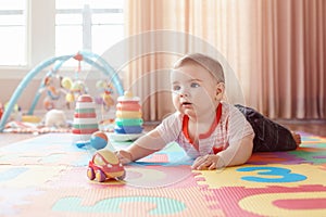 Baby crawling on playmat. Early education development photo