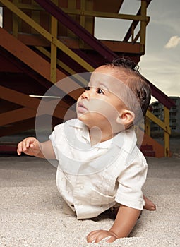 Baby crawling in the sand