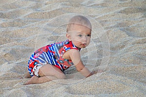 Baby crawling in a soft beach sand