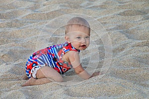 Baby crawling in a soft beach sand