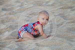 Baby crawling in a soft beach sand