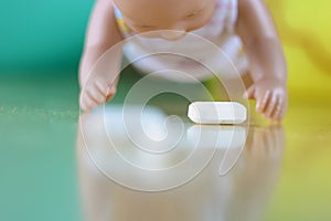 Baby crawling towards a spilled pill