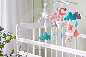 Baby crib mobile with stars, clouds and moon. Kids handmade toys above the newborn crib