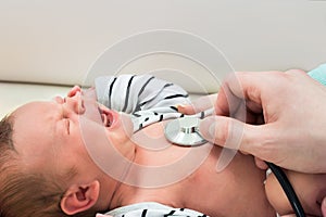 Baby crying while examined by doctor