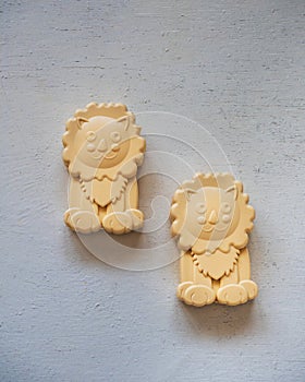 Baby curly soap in the form of a cheerful lion on a white wooden table