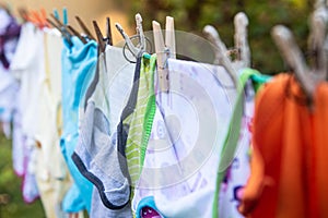 Baby cute clothes hanging on the clothesline outdoor. Child laundry hanging on line in garden