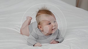 Baby Development. Cute Newborn Boy Lying On Bed On His Tummy