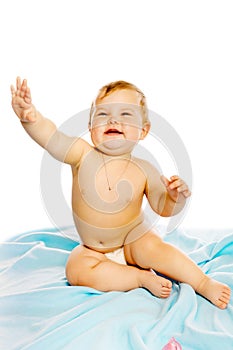 Baby in diaper sitting on a blue blanket. Isolated