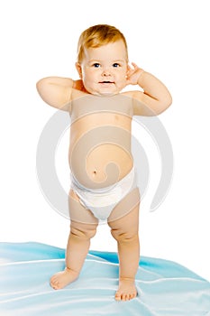 Baby in diaper standing on a blue blanket. Studio. Isolated