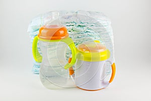 Baby diapers and bottles on a white background