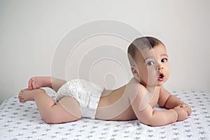 Baby in diapers lying on her belly