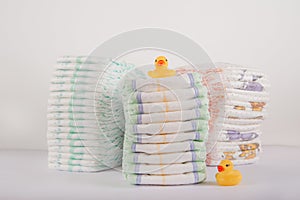 Baby diapers on a white background close-up and copy space. Accessories for a newborn diapers, pacifier, bottles, teether, ducks f