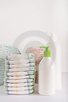 Baby diapers on a white background close-up and copy space. Accessories for a newborn diapers, pacifier, bottles, teether, ducks f