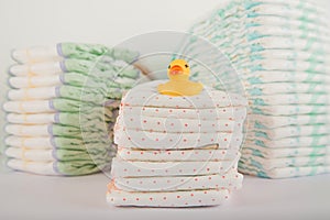 Baby diapers on a white background close-up and copy space. Accessories for a newborn diapers, pacifier, bottles, teether, ducks f