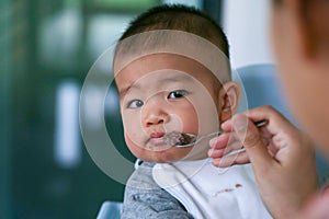 The baby does not want to eat the food that the mother feeds.