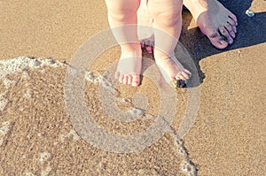 Baby doing his first steps on the beach