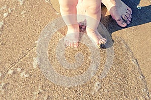 Baby doing his first steps on the beach