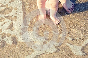 Baby doing his first steps on the beach