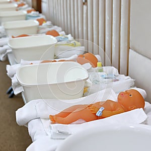 Baby doll in nursery class room with parents training child care