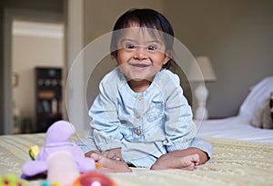 Baby with down syndrome and happy child portrait on bed with joy of Mexican special needs kid relaxed in home. Happy