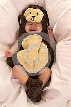 Baby dressed as a monkey crying